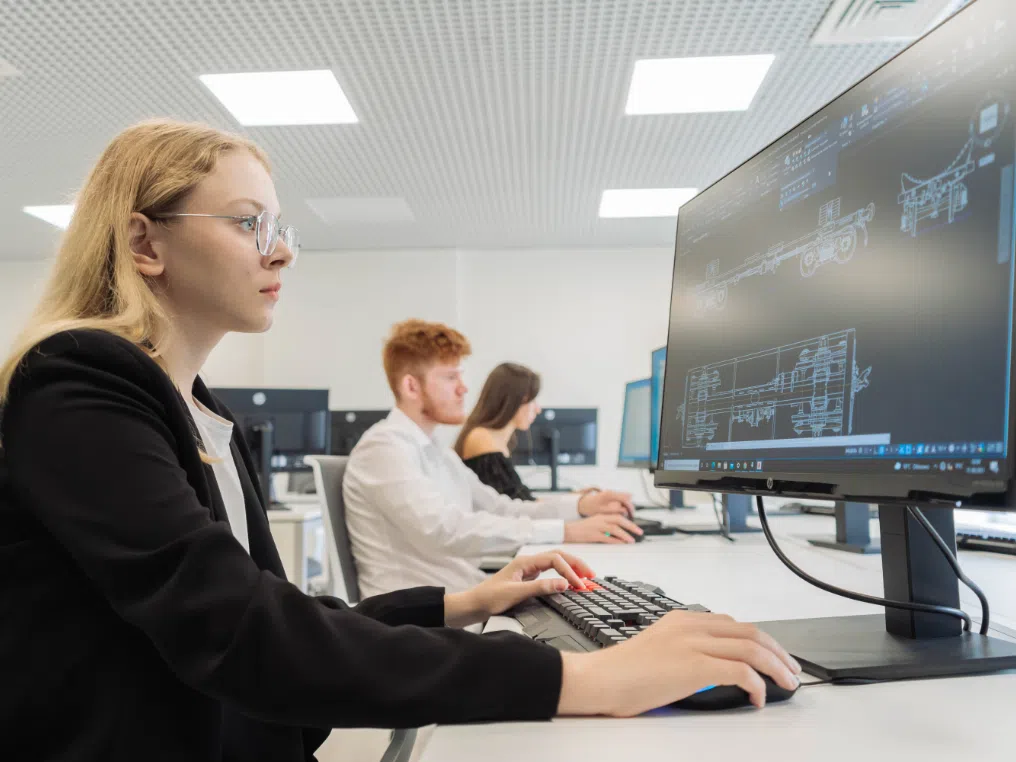 Eine Frau sitzt vor einem Computermonitor.