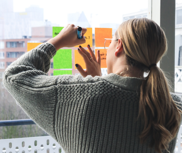 Studentin klebt Post-tits ans Fenster